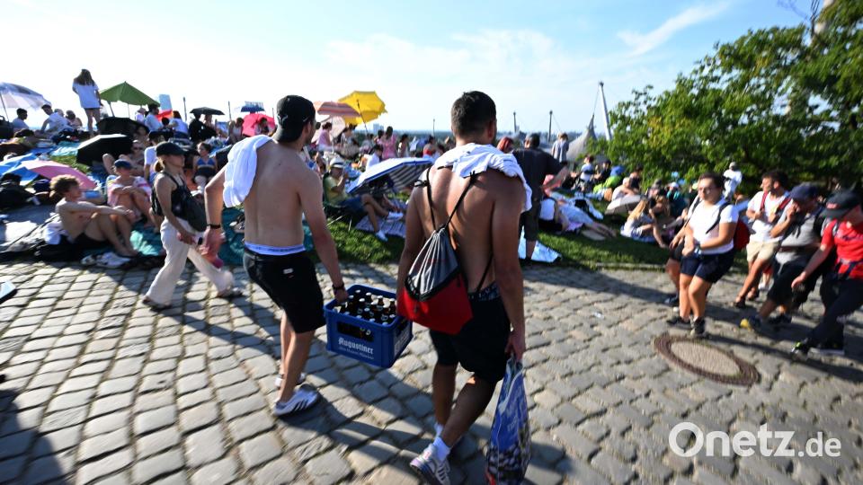 Maximilian und Niclas tragen vor dem Taylor Swift Konzert einen Kasten Bier den Olympiaberg herunter. Bild: Felix Hörhager /dpa