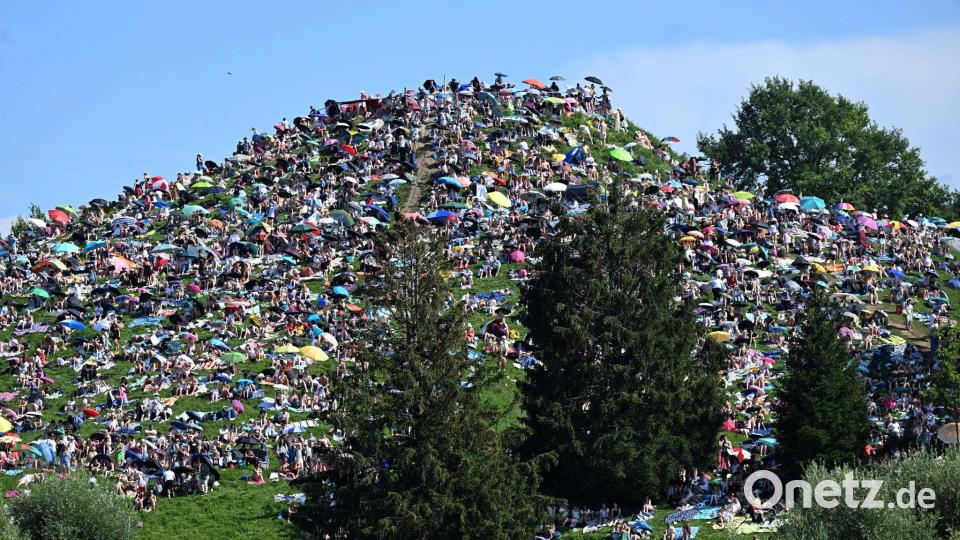 Viele Fans setzten sich auf den Olympiaberg im Münchner Olympiapark, um dem Konzert von Taylor Swift zu lauschen. Bild: Felix Hörhager/dpa