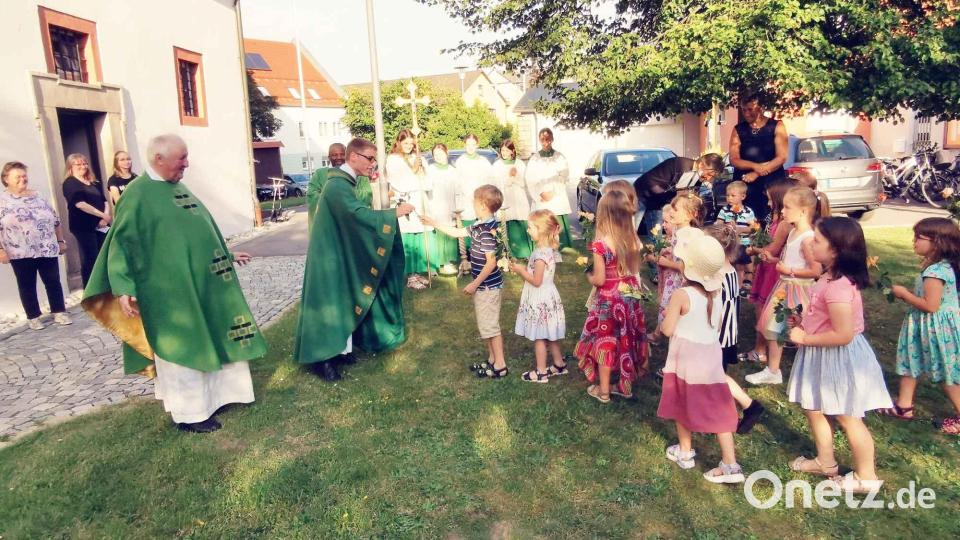 Die Kindergartenkinder begrüßen den Primizianten vor der Kirche mit einem Lied und Rosen. Bild: gz