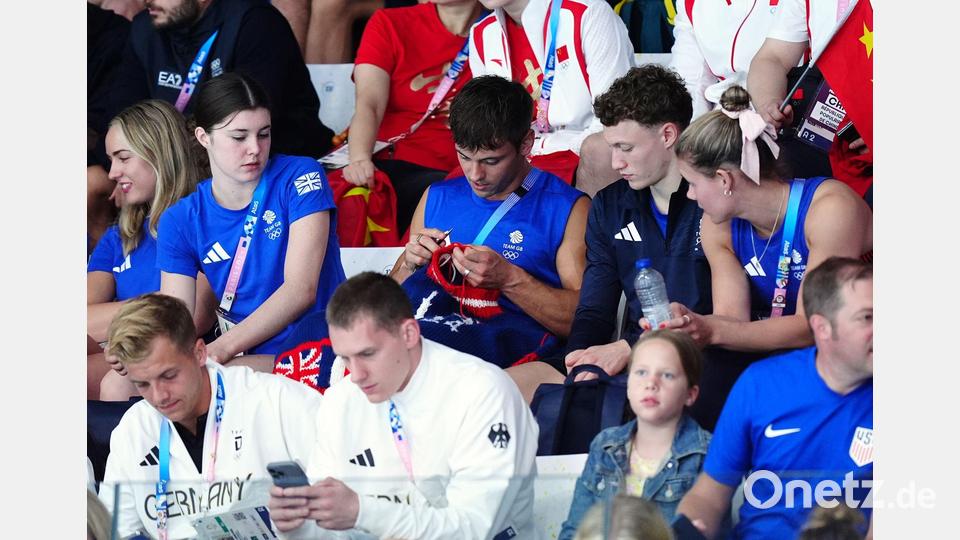 Tom Daley strickt während eines Olympia-Wettkampfs auf der Tribüne. Bild: Mike Egerton/PA Wire/dpa