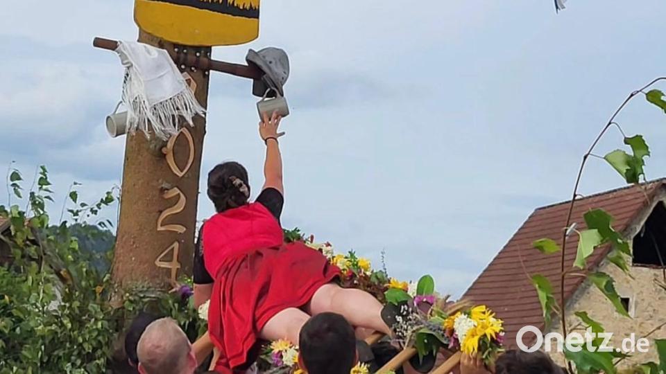 Oberkirwamoidl Sabrina Sebald recht sich nach Krügel und Hut für ihren Burschen. Bild: Kirwagemeinschaft Holnstein