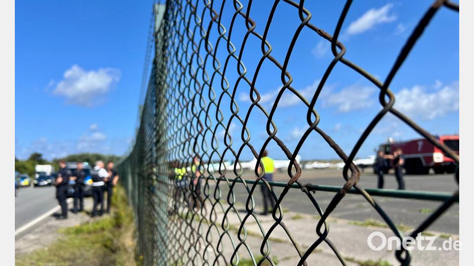 Am Flughafen Sylt sind Polizisten schnell zur Stelle, nachdem Klima-Aktivisten der Letzten Generation ein Loch in den Zaun geschnitten haben und auf das Gelände gelangt sind. Bild: Lea Sarah Albert/dpa