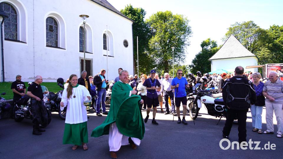 Voller Elan segnet Pfarrer Albert Hölzl mit Weihwasser Motorräder und Fahrer. Bild: fvo
