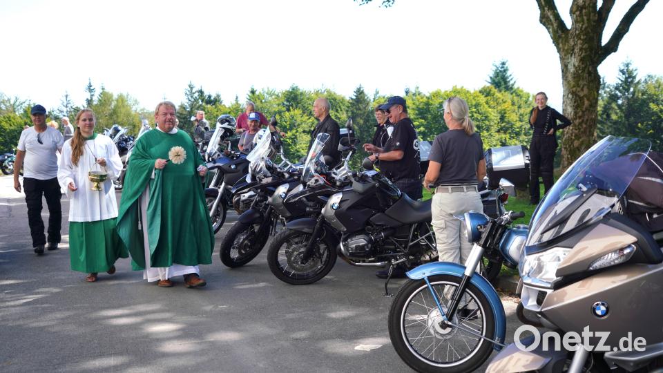Auch hinter der Fahrenbergkirche stehen Motorräder und ihre Fahrer, die Pfarrer Albert Hölzl segnet und mit Weihwasser besprüht Bild: fvo