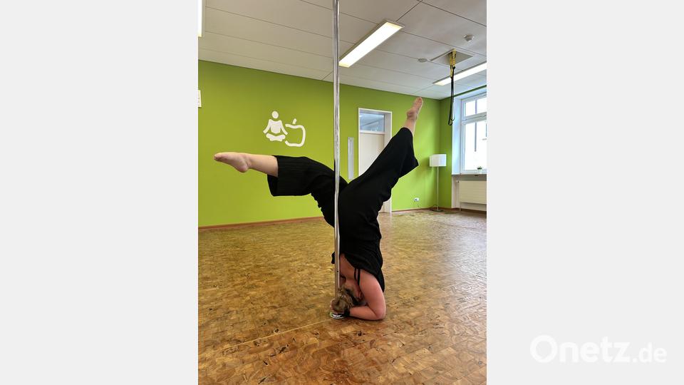 Kopfstand an der Poledance-Stange: Im Poledance-Einsteiger-Workshop kann man diese und weitere Figuren lernen. Bild: Johanna Senft