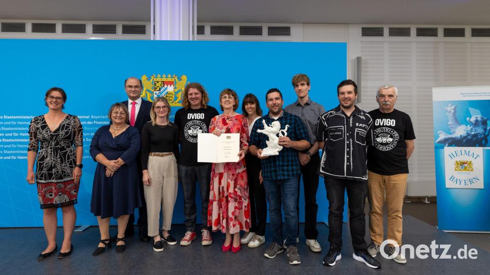 Zehn Vertreter von Ovigo nehmen stellvertretend für das gesamte Theaterteam in Nürnberg den Bayerischen Heimatpreis entgegen. Vorsitzende Ilona Glück hält die Urkunde, stellvertretender Vorsitzender André Gießübl den Porzellanlöwen. Hinten links Finanz- und Heimatminister Albert Füracker, Zweiter von rechts Ovigo-Intendant Florian Wein.. Bild: StMFH Graser Florian