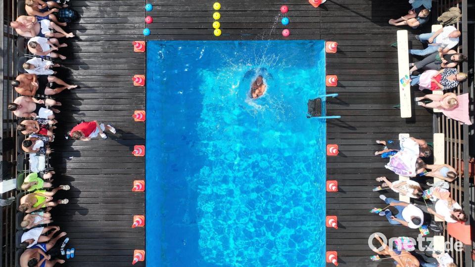 Peter Klages springt beim Wettbewerb um die beste Arschbombe vom Beckenrand in das Schwimmbecken. Bild: Sascha Thelen/dpa