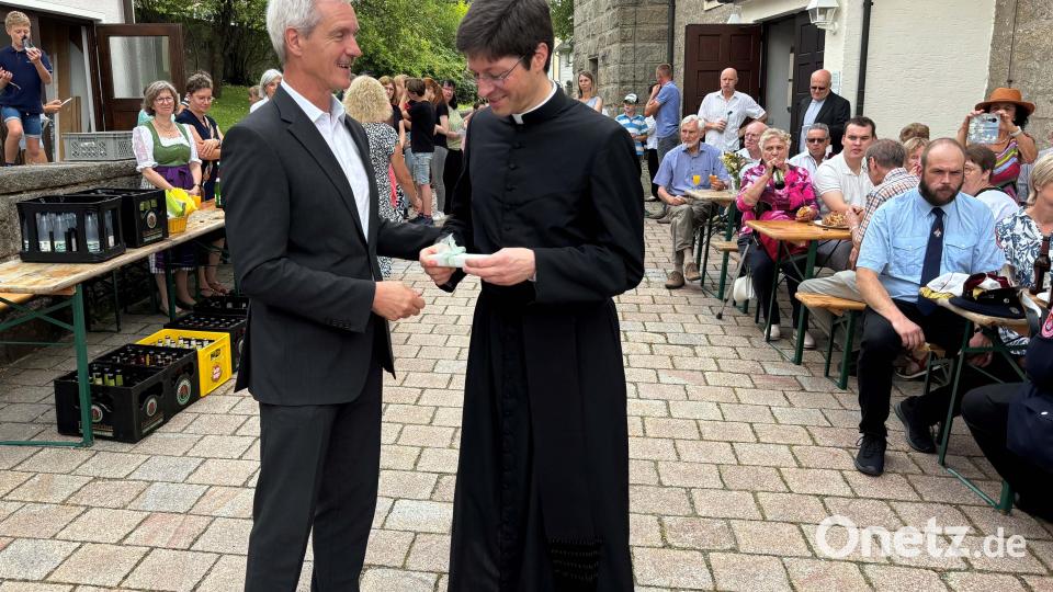 Kirchenverwalter Josef Völkl überreicht nach den Abschiedsworten das gemeinsame Geschenk von Kirchenverwaltung, Theatergruppe, Frauenbund und KAB Männerverein an Herrn Pfarrer Gierl Bild: cro