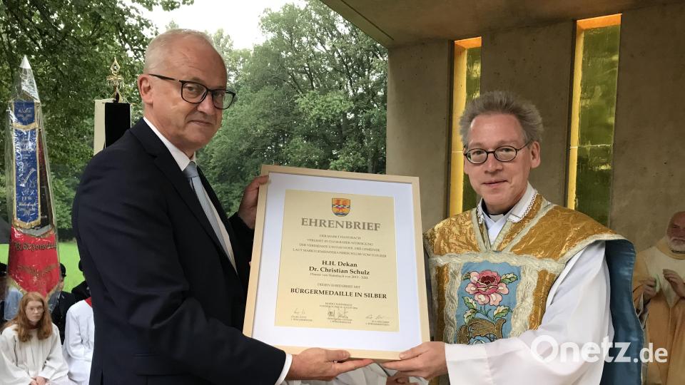 Bürgermeister Bernhard Lindner (links) überreicht Pfarrer Christian Schulz Ehrenbrief, Medaille, Anstecknadel und Urkunde zur Hahnbacher Bürgermedaille in Silber. Bild: mma