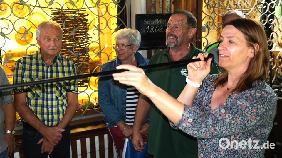 Kreisrätin Ulrike Pelikan-Roßmann testet die neue Schießvariante mit Blasrohr und Pfreil, beobachtet vom Schützenmeister Ulrich Götz von der Schützengilde "Kleeblatt" (Zweiter von rechts). Bild: Hirsch