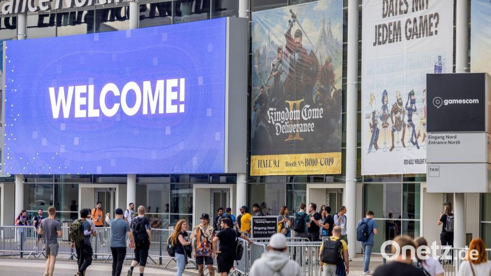 Besucher der Eröffnungsshow der Gamescom gehen zum Eingang der Kölner Messe. Bild: Thomas Banneyer/dpa
