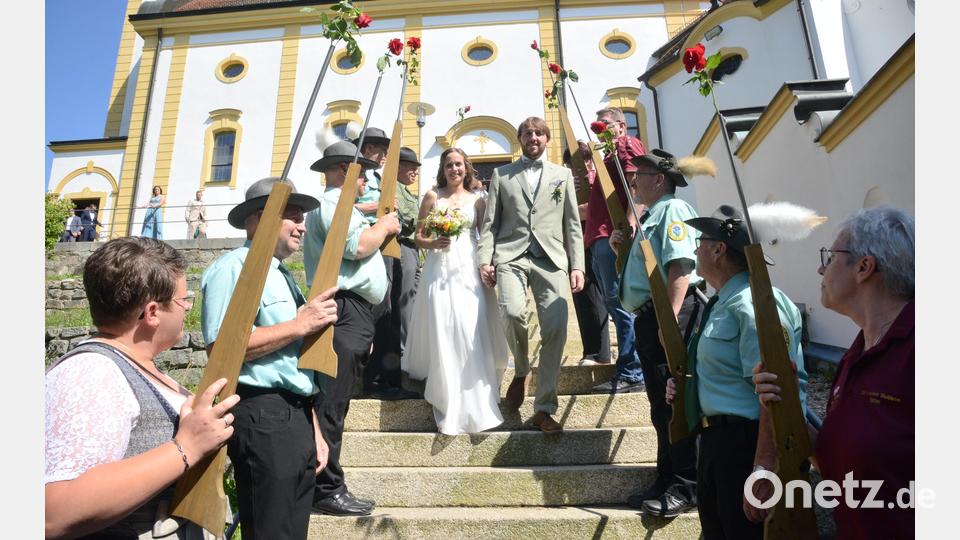 Durch ein Spalier mit roten Rosen in den Gewehrläufen der Abordnungen der Schützenvereine Grenzland Waldheim und &quot;Enzian&quot; Frankenreuth schritt das Brautpaar von der Kreuzbergkirche zum Plateau. Bild: bey