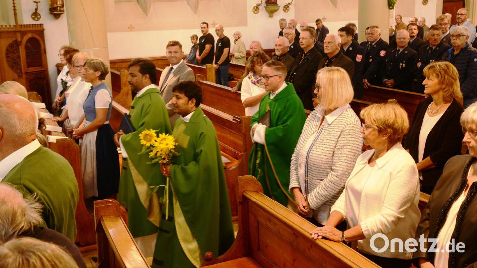 Zum letzten Mal betritt Pater John (mit den Sonnenblumen in der Hand) die Stadtpfarrkirche und gemeinsam mit Stadtpfarrer Adam Karolczak (rechts) und Pater John aus Linz seinen Abschiedsgottesdienst zu halten. Bild: bey