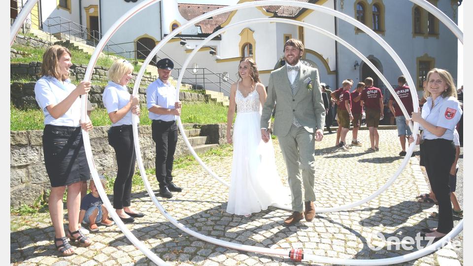 Die Feuerwehr Neudorf hatte für das Brautpaar eine Spirale aus einem Feuerwehrschlauch aufgestellt, durch die das David und Luisa Piehler schritten, bevor sie dann ein &quot;brennendes&quot; Häuschen per Schlauch und Wasserstrahl löschen mussten. Bild: bey