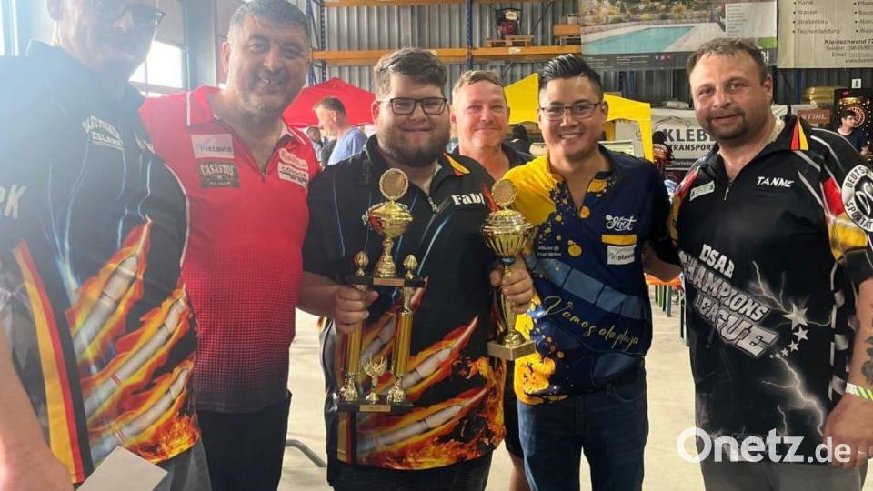 Der Siegerpokal mit Wanderpokal und die 150 Euro gingen beim Turnier &quot;301 Single Out&quot; an Fabian Fischer von den Dartfreunden Eslarn. Gratulationen kamen von Dartchef Martin Bauer und Mensur Suljovic (von links) sowie von Vize Thomas Bösl und Rowby-John Rodriguez (von rechts). Bild: gz