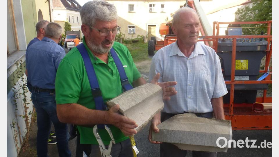 Die beiden Gesimssteine, die abzustürzen drohten, zeigen Kirchenpfleger Josef Leonhardt (links) und Mesner Josef Binninger. Bild: mad