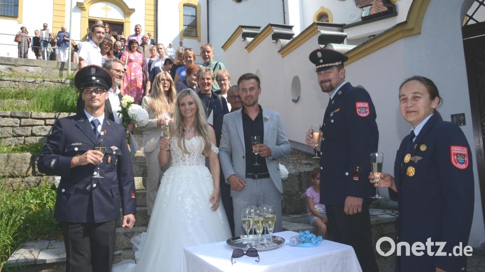 Eine Abordnung der Feuerwehr Eslarn dem Brautpaar überbringt Glückwünsche und lädt das Brautpaar zu einem Glas Sekt ein. Bild: bey
