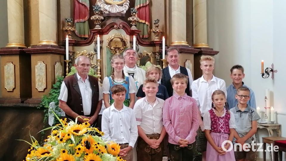Pfarrer Slawomir Niemczewski (hinten, Dritter von links), die Mesner Hans Hiller (links) und Johannes Zeindl (hinten, Vierter von links) mit den Messdienern, die in Tracht beim Festgottesdienst ministrierten. Bild: Marion Hollweck