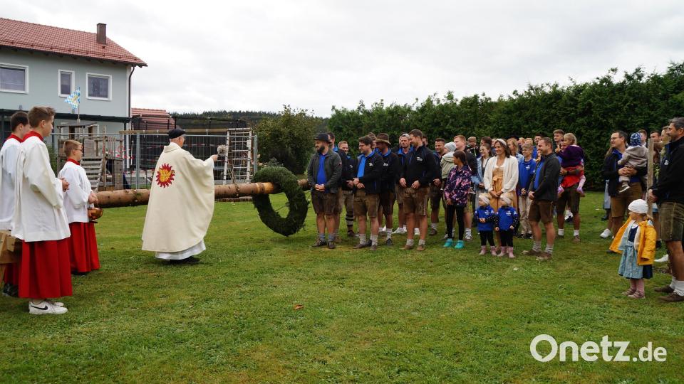 Pfarrer Herbert Rösl segnet den Kirwabaum und die gesamte Kirwagesellschaft. Wegen des starken Windes entschieden sich die Verantwortlichen dafür, den Baum erst im Laufe der Woche aufzustellen Bild: wel