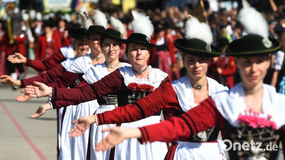 Trachtlerinnen ziehen auf die Theresienwiese. Bild: Felix Hörhager/dpa