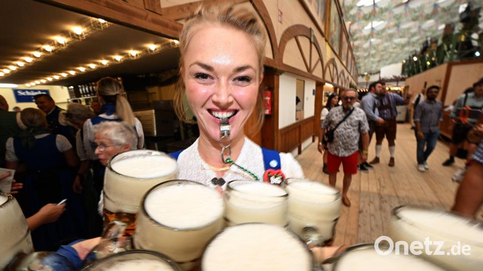 Die Bedienungen schleppen die Maßkrüge. Bild: Felix Hörhager/dpa