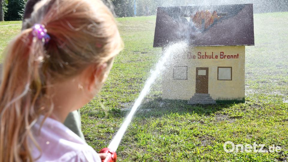 Die Kleinen dürfen ein Feuer löschen. Bild: Petra Hartl
