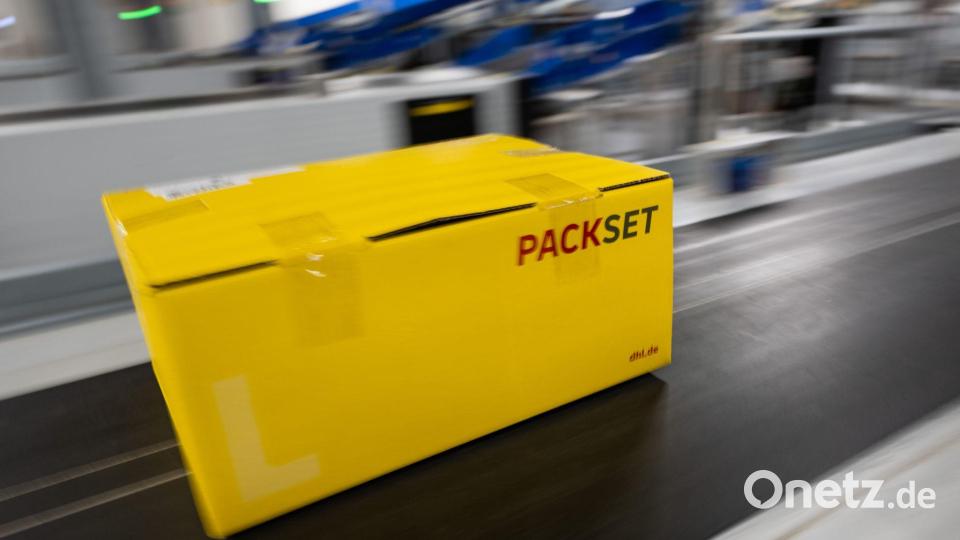 Ein Paket rollt über das Laufband eines DHL-Paketzentrums. Bild: Christophe Gateau/dpa