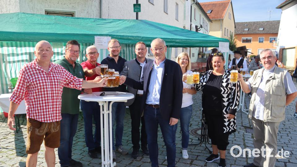 Festlbürgermeister Gerhard Schnabel (links) stößt mit Vereinsvertretern, Markträten, Bürgermeister Erwin Geitner (Sechster von links) und Pfarrer Slawomir Niemczewski (rechts) auf den 18. Riedener Marktsonntag an. Bild: mrr