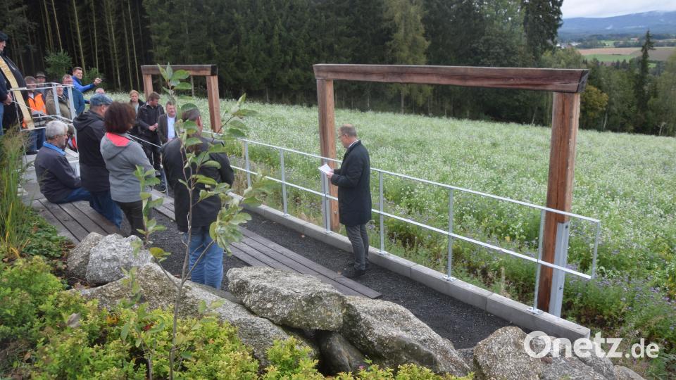 Links durch ein Holzportal wird das Landschaftskino mit den beiden Sitzreihen und per Balkenrahmen symbolisierten Kinoleinwänden betreten. Bild: fz