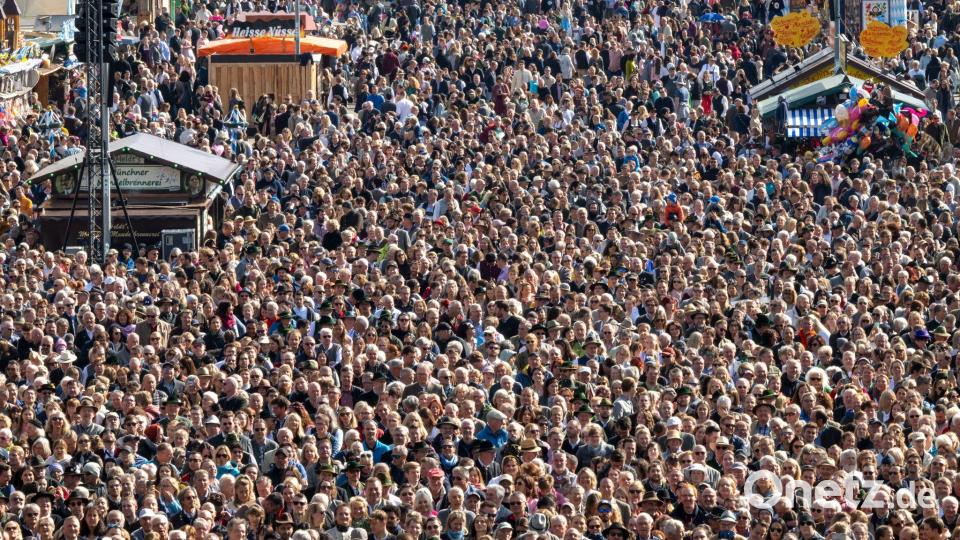 Dicht drängen sich die Wiesn-Gäste beim Platzkonzert zwischen den Zelten und Fahrgeschäften. Bild: Peter Kneffel/dpa
