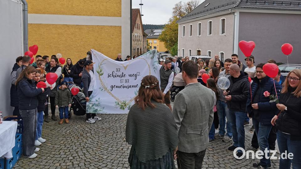 Auf das Brautpaar wartet eine große Abordnung von Freunden. Doch fürs Ausschneiden des Stoffherzes gibt&#039;s nur zwei kleine Scheren. Bild: Portner