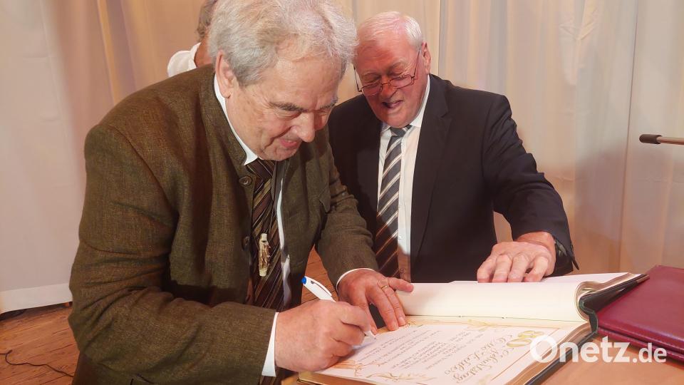 Der Gutenecker Bürgermeister Hans Wilhelm (rechts) hat das Goldene Buch der Gemeinde mitgebracht, in das sich Otto Zeitler anlässlich seiner Geburtstagsfeier eintragen darf. Bild: Amann