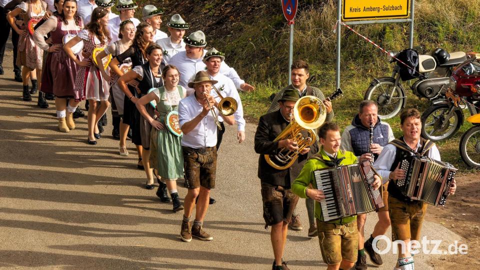 Begleitet von Musikanten aus verschiedenen Gruppen ziehen die zwölf Kirwapaare in Schleißdorf zum Baumaustanzen. Bild: gri