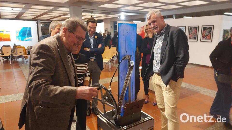 Herbert Tischler versucht sich an einem Gerät, das Schrauben magnetisch nach oben transportiert. Bild: Kunz
