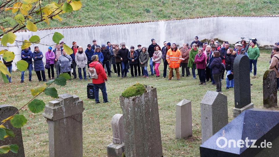 Stadtarchivar Johannes Hartmann (Mitte, rote Jacke) fasste die Geschichte des Friedhofs zusammen und vermittelte den Besuchern Hintergrundwissen zu einzelnen Grabsteinen. Bild: mfh