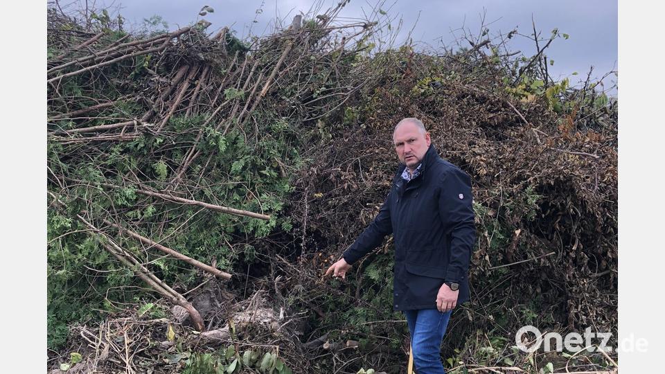 Der Manteler Bürgermeister Richard Kammerer ist stinksauer. Er zeigt auf einen dicken Wurzelstock mit Erde und Steinen, der für einen Defekt des Häckslers sorgen kann. Bild: sei