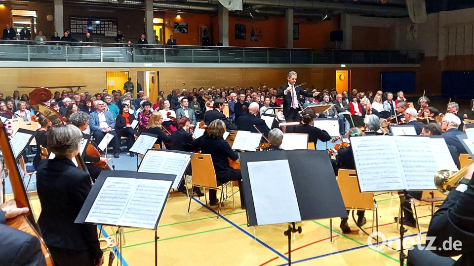Das Orchester mit Dirigent Michael Falk und im Hintergrund das konzentrierte Publikum des Jubiläumskonzerts. Bild: lg