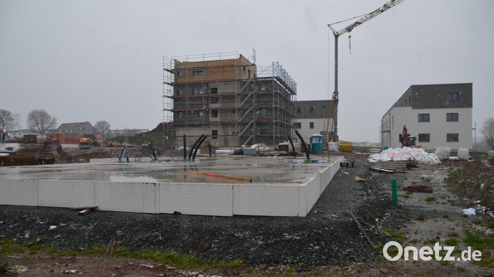 3 der 14 geplanten Mehrfamilienhäuser stehen bereits, bei zweien ist auch die Außenfassade schon angebracht. Für ein viertes Gebäude ist die Bodenpatte gegossen (vorne). Wann die Arbeiten weitergehen, ist derzeit unklar. Die Baustelle ist laut Anwohnern schon seit ein paar Tagen verwaist. Bild: ak