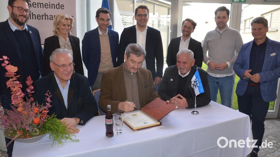 Weiherhammers Bürgermeister Ludwig Biller (rechts) freut sich über den Eintrag der Gäste ins Goldene Buch. Bild: Kunz