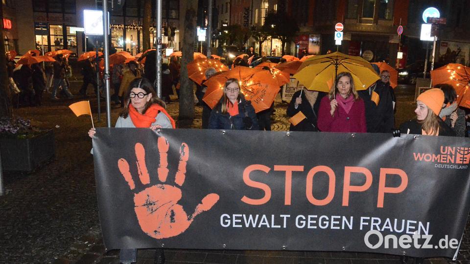 Mit orangefarbenen Regenschirmen zogen die Teilnehmerinnen und Teilnehmer des Schweigemarschs mit kurzen Stopps für Statements durch die Innenstadt. Bild: Kunz