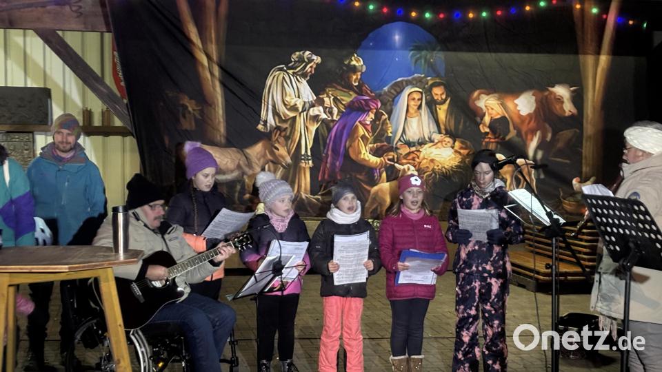 Der Kinderchor aus der Pfarrei Herz Jesu singt bei der offiziellen Eröffnung des Krippenwegs im Fischer-Garten. Bild: ge