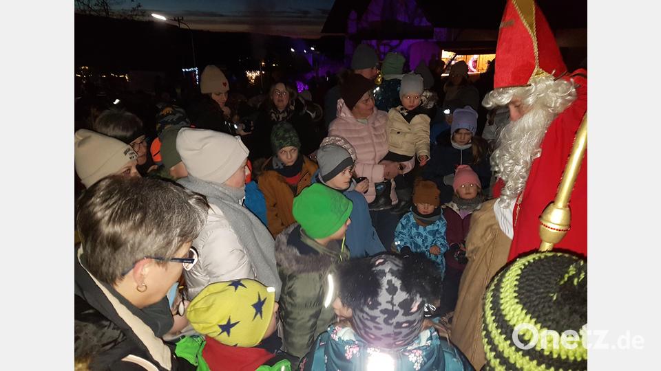 Die Kinder scharen sich um den Nikolaus, der jedem einen Schokonikolaus überreicht. Bild: gi