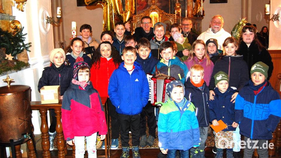 Zu einer gelungenen und ansprechenden Feier wurde der Gottesdienst anlässlich des 70. Geburtstages von Pfarrer Alfons Forster (hinten rechts) in der Pfarrkirche in Michldorf. Im Namen der Pfarrgemeinde gratulierten Pfarrgemeinderatssprecher Georg Hammer (hinten links) und Kirchenpfleger Alfons Stangl (hinten mitte) und auf humorvolle Weise die Mädchen und Buben vom Kreis Junger Familien. Bild: grm