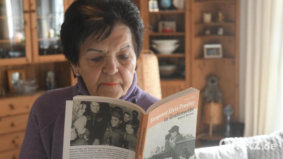Dagmar Kiermeier blättert in dem Buch "Sergeant Elvis Presley in Grafenwöhr". Das Foto auf der Buchrückseite dokumentiert ihre Begegnung mit dem Weltstar als Zwölfjährige in Hirschau. Bild: Gabi Schönberger