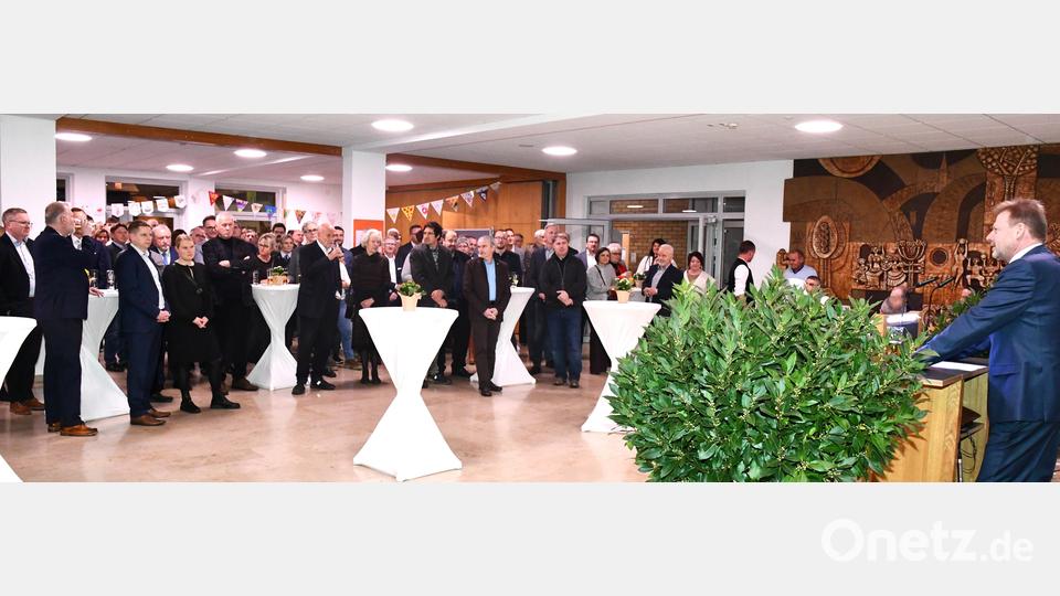 Bürgermeister Alwin Märkl (rechts, am Rednerpult) appelliert beim Neujahrsempfang der Gemeinde Freudenberg, sich für die Gesellschaft zu engagieren. Bild: sche