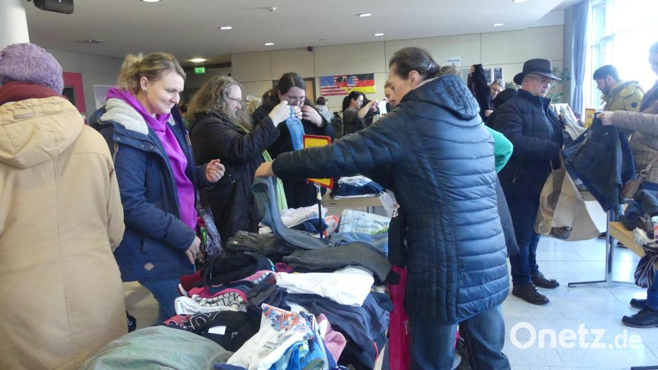 Die Besucher stürzen sich auf Kinderkleidung, die auf langen Tischreihen sortiert liegt. Bild: rn