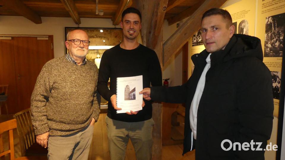 Roman Schneider (Mitte) übergibt die Dokumentation seiner Arbeit an Bürgermeister Marcus Gradl und Karlheinz Keck. Bild: rn