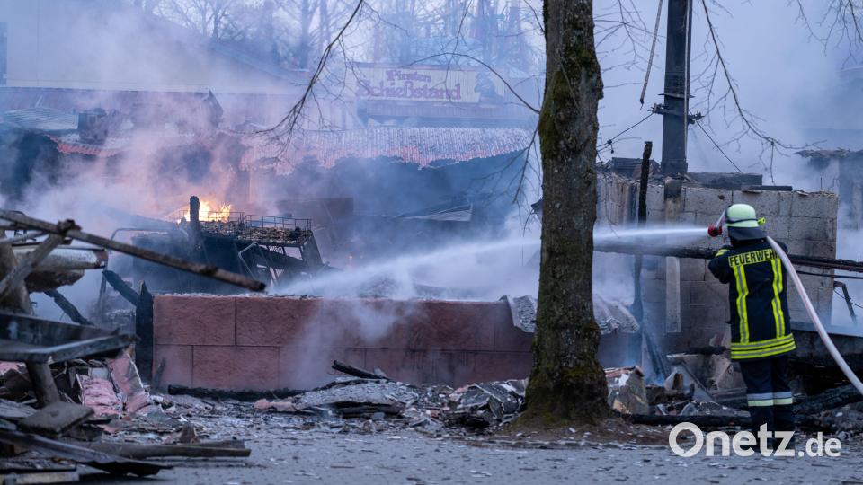 Ein Feuerwehrmann strahlt Wasser auf verkohlte Gebäude- und Einrichtungsteile, im Hintergrund ist der Schrifzug &quot;Piraten Schießstand&quot; zu lesen. Im Freizeit-Land Geiselwind ist ein Feuer ausgebrochen. Ein Kiosk und der Gaststättenbereich im Eingang des Freizeitparks sind vollständig zerstört. Bild: Pia Bayer