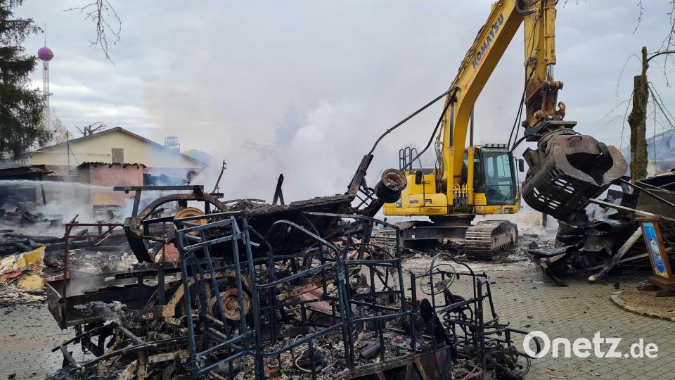 Eine von Feuer geschwärzte Metallkonstruktion steht neben einem Bagger. Keine zwei Wochen vor Saisonstart war im «Freizeit-Land Geiselwind» in Bayern ein Feuer ausgebrochen. Nach Polizeiangaben lag der Brandherd nach bisherigen Erkenntnissen in der Küche eines Restaurants. Bild: Pia Bayer