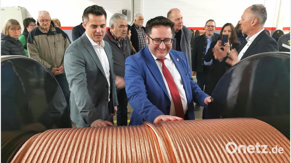 Wie fühlt sich ein Kupferseil an? Bürgermeister Rudolf Teplitzky (vorne von links) und Staatssekretär Tobias Gotthardt wollen es im DLB-Werk Oberviechtach wissen; rechts Geschäftsführer Albin Dickert. Bild: Portner